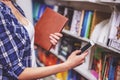 Girl with gadget at the bookshop Royalty Free Stock Photo