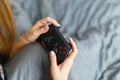 Girl gamer playing video game with wireless joystick at home. Gamepad in female hands close-up, gaming addiction concept, woman Royalty Free Stock Photo