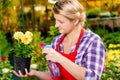 Girl gardener sprinkles flowers with water