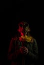 Girl in gas mask with flowers in hands. Royalty Free Stock Photo