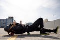 Girl in a gas mask lies on a skateboard against the background of a pipe plant Royalty Free Stock Photo