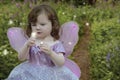 Girl gazing at a glowing fairy in her hand