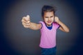 Girl getting angry fist shows on a gray background Royalty Free Stock Photo