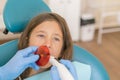 girl getting dental filling treatment at molar tooth with ultraviolet technology. Image of little girl having her teeth checked by