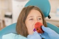 Girl getting dental filling treatment at molar tooth with ultraviolet technology. Image of little girl having her teeth Royalty Free Stock Photo