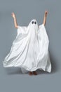 A girl in a Ghost costume on a gray background in the Studio. Halloween