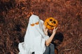 girl in ghost costume with jack pumpkin