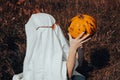 girl in ghost costume with jack pumpkin