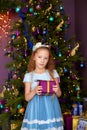 Girl with gift box near christmas tree Royalty Free Stock Photo