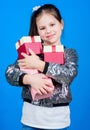 Girl with gift boxes blue background. Black friday. Shopping day. Child carry lot gift boxes. Kids fashion. Surprise Royalty Free Stock Photo