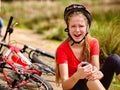 Girl girl fell off bike. Cyclist girl keeps self for bruised knee. Royalty Free Stock Photo