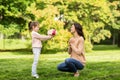 Girl giving with flowers to mother in summer park