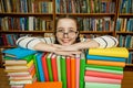 Girl in glasses with books in the library Royalty Free Stock Photo