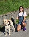 Girl with glasses and her Labrador dog smiling happily