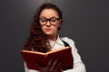 Girl in glasses holding book and reading Royalty Free Stock Photo