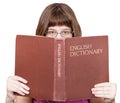 Girl with glasses looks over English Dictionary Royalty Free Stock Photo