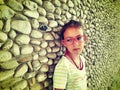 Girl with glasses near a stone wall Royalty Free Stock Photo