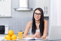 Girl in glasses studding on kitchen.