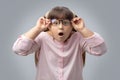 Girl with glasses surprised . disciple shocked. gray background . Royalty Free Stock Photo