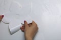 The girl glues the cut out elements from self-adhesive paper, to mask the defects of the white door. Royalty Free Stock Photo