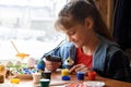 A girl glues elements to crafts with a glue gun