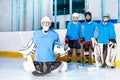 Girl goaltender in butterfly position on ice rink