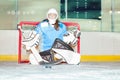 Girl goaltender crouches in crease to protect net