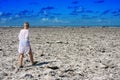 Girl goes on the coast from dead corals