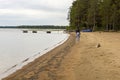 Girl goes on coast of lakeside in taiga