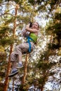 the girl goes down the extreme cable car on the background of the forest