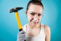 The girl in goggles holds a hammer in her hand and nails in her teeth Royalty Free Stock Photo