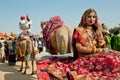 Girl with gold jewelry sits in camel cart of Desert Festival