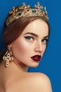 Girl with a golden crown and golden earrings.