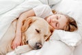 Girl with golden retriever dog in the bed Royalty Free Stock Photo