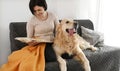 Girl with golden retriever dog reading book