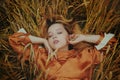 A girl in a golden wheat field lies in a dress. A woman is sleeping in nature, the model has closed her eyes and enjoys fresh air Royalty Free Stock Photo