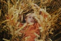 A girl in a golden wheat field lies in a dress. A woman is sleeping in nature, the model has closed her eyes and enjoys fresh air Royalty Free Stock Photo