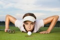 Girl golf player blowing ball into cup. Royalty Free Stock Photo