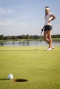 Girl golf player putting on green. Royalty Free Stock Photo