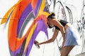 Girl graffiti artist spray painting wall art Royalty Free Stock Photo