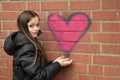 Girl and graffiti heart on a wall Royalty Free Stock Photo