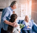 The girl and grandfather giving flowers to a grandmother. Royalty Free Stock Photo