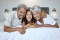 Girl, grandparents and relax on bed with smile, happy and love with family bonding together in home. Portrait on latino