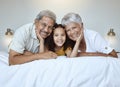 Girl, grandparents and smile on bed for portrait, together and bedroom for bonding, love and happy in home. Elderly, man Royalty Free Stock Photo