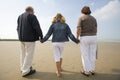 Girl and grandparents walking at the beach Royalty Free Stock Photo