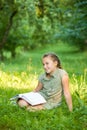 The girl on a grass with book