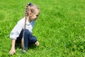 Girl with in the grass catches grasshopper