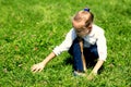 Girl with in the grass catches grasshopper