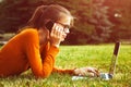 Girl in grass using laptop and smart phone Royalty Free Stock Photo