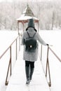 Girl in gray coat on a bridge in winter